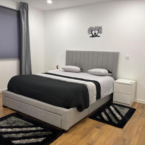 a bedroom with a bed with a black and white blanket at T1 Luxgarden in Lamego