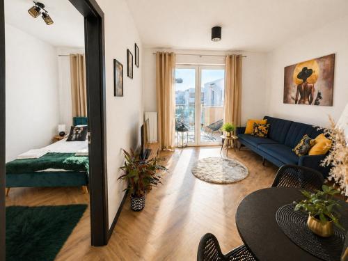 a living room with a blue couch and a mirror at Ami Luxury Residence VI CENTRUM - parking- in Iława