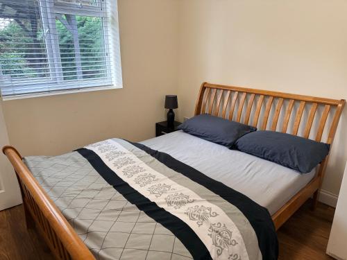 a bedroom with a bed with blue pillows and a window at Chiltern Nursuries in Amersham