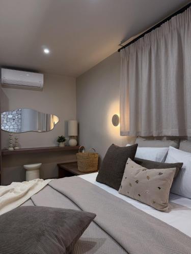 a bedroom with a bed with pillows and a window at A Casa Di Zoi in Archangelos