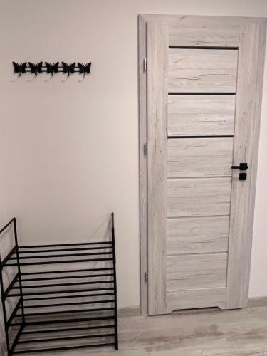 a wooden door in a room with a chair at Apartament Raj in Biała Podlaska