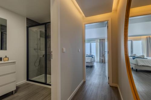 a bathroom with a walk in shower next to a bedroom at Azor Signature Flats - IV in Ponta Delgada