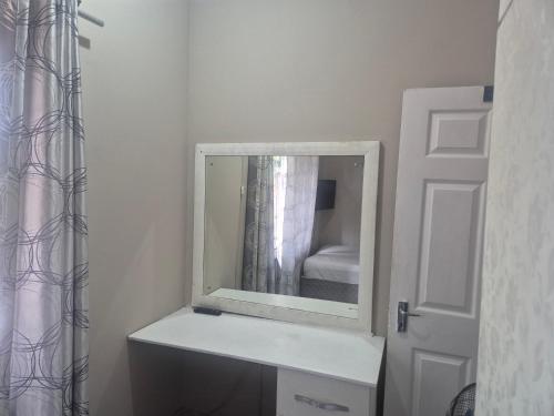 a mirror on top of a dresser in a bathroom at BluSash in Durban