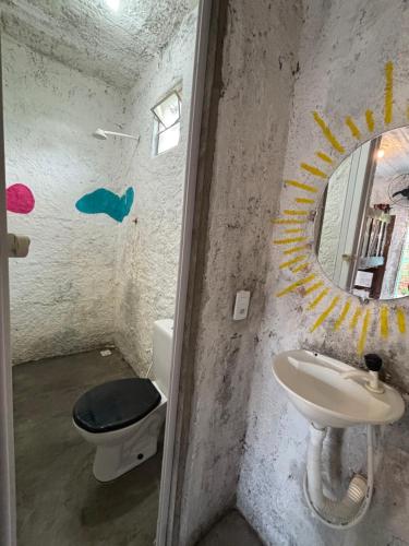 a bathroom with a toilet and a sink and a mirror at Hostel Flor da Vida in Canoa Quebrada
