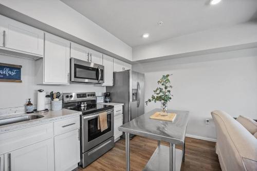 a kitchen with white cabinets and a table with a plant at Steps to Dome Breathtaking views parking AC! in Tacoma