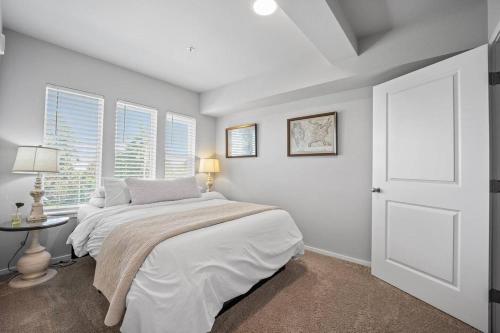a white bedroom with a bed and a window at Steps to Dome Breathtaking views parking AC! in Tacoma