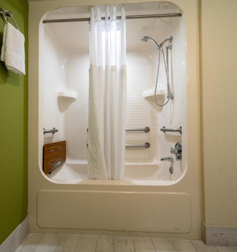 a bathroom with a shower and a tub with a shower curtain at Sleep Inn Murfreesboro Shopping District in Murfreesboro