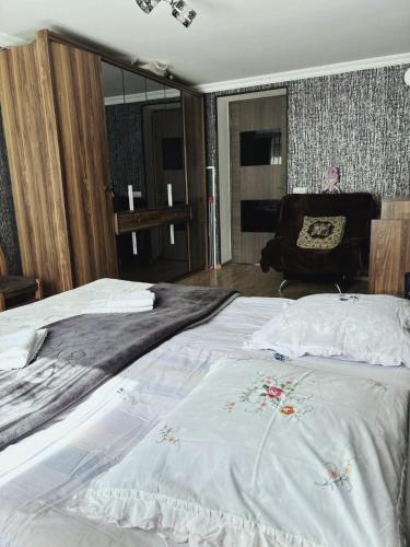 a bedroom with a large bed and a chair at Dachi Apartment in Sighnaghi