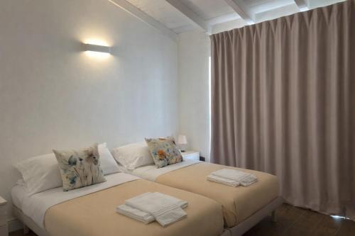 a bedroom with two beds with towels on them at Apt. Virgo - Oasi di Menaggio in Menaggio