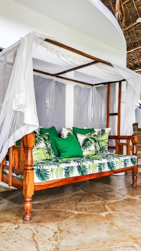 a bed with a canopy in a room at Fasha House Malindi in Malindi