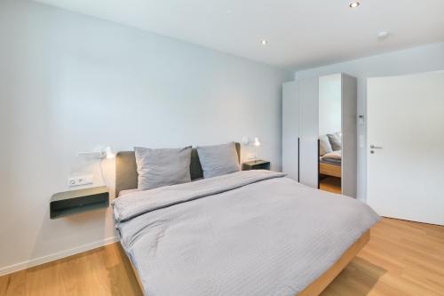 a bedroom with a large bed with white sheets at Burgblick Apartment Weinlaub in Bernkastel-Kues