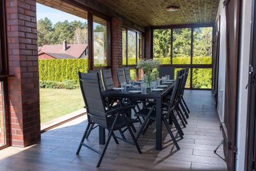 a black dining room table and chairs on a patio at Dom Nad Wodą - Smolarnia in Smolarnia