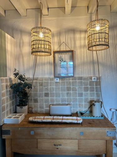 a kitchen with two lights and a table with two laptops at Gite Authentique Évasion in Saint-Mard-de-Vaux