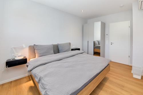a white bedroom with a large bed in it at Burgblick Apartment Schieferblau in Bernkastel-Kues