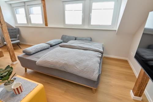 a bed in a room with two windows at Burgblick Appartement Riesling Gold in Bernkastel-Kues