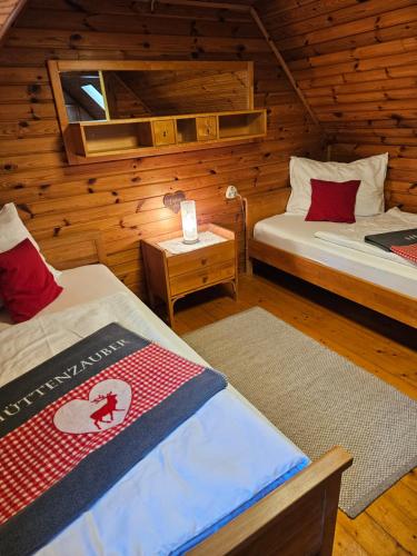 a room with two beds in a log cabin at Almhütte, Ferienhaus Hadn Hube in Paisberg