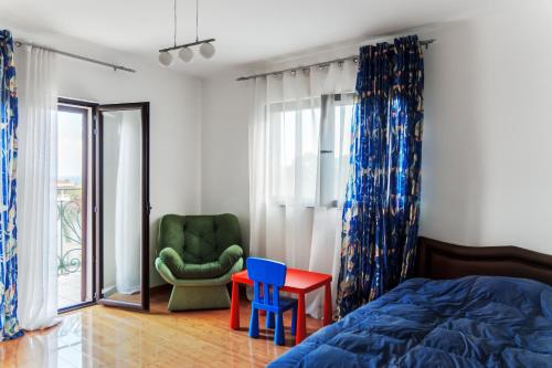 a bedroom with a bed and a chair and a table at Paradise Garden Villa in Bečići