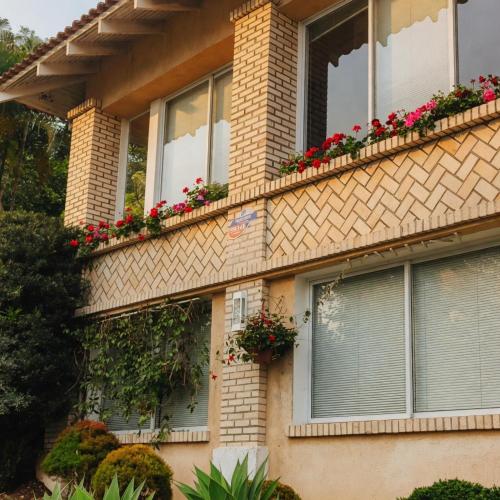 a house with flowers on the side of it at Bela Vista Hospedagem in Joinville