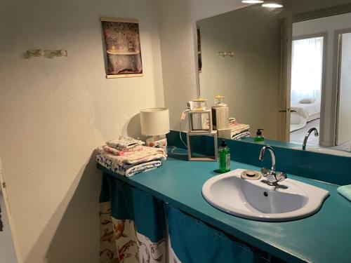 a bathroom counter with a sink and a mirror at Sand Home in Le Puy-en-Velay