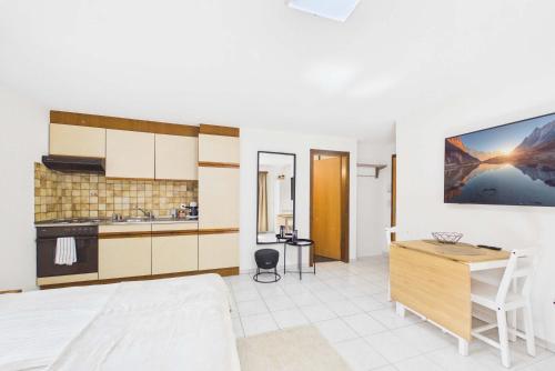 a room with a kitchen and a desk in it at Cozy Studio in Brig in Gamsen