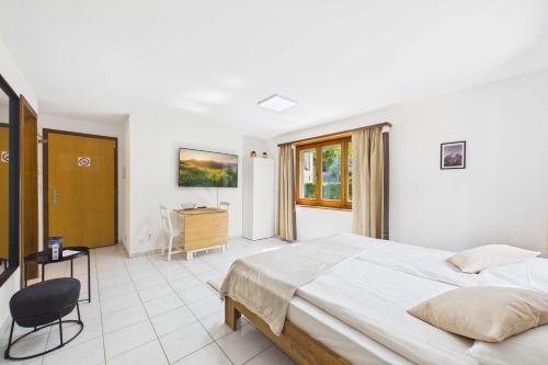 a bedroom with a large bed and a desk at Cozy Studio in Brig in Gamsen