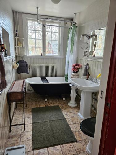 a bathroom with a black tub and a sink at Furubo in Orkelljunga