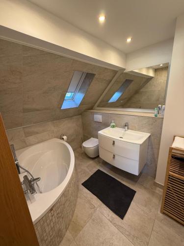 a bathroom with a tub and a toilet and a sink at StayKassel Apartment in Kassel