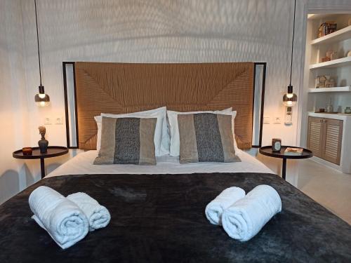 a bedroom with a large bed with two towels on it at ÉLYSÉE Boutique in Katavatí