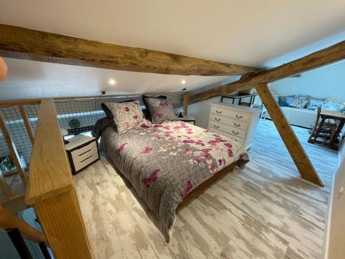 a bedroom with a bed and a dresser at Le Chai d'Auguste in Pauilhac