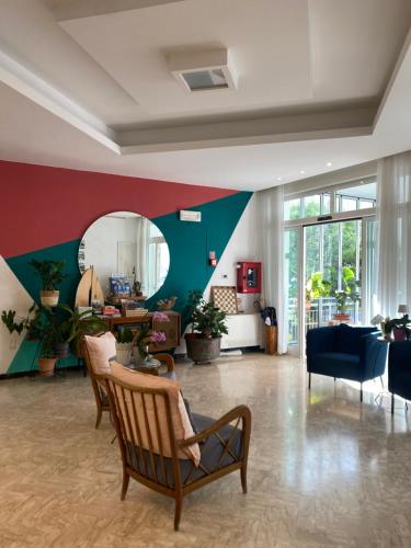 a large living room with chairs and a mirror at Hotel St. Moritz in Rimini