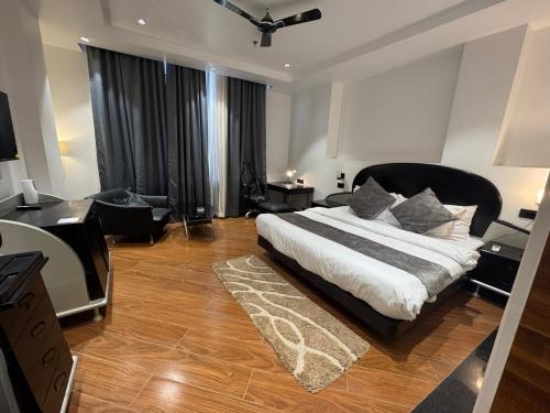 a bedroom with a large bed with a black headboard at CNS Hotels in Ghaziabad