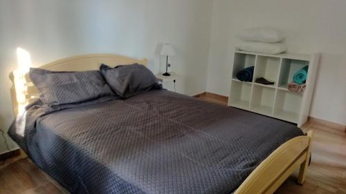 ein Schlafzimmer mit einem Bett mit grauer Bettdecke in der Unterkunft Boulevard Roca in Trelew