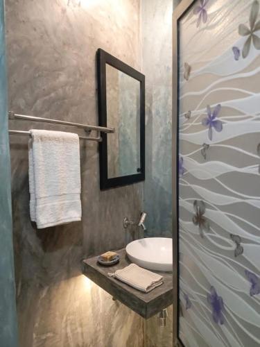 a bathroom with a sink and a mirror at Ayaan Beach Home in Dodanduwa