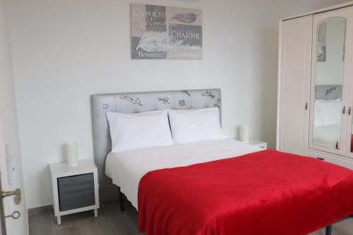 a bedroom with a bed with a red blanket at Fifty`s House 1 By Sam Houses in Ribeira Brava