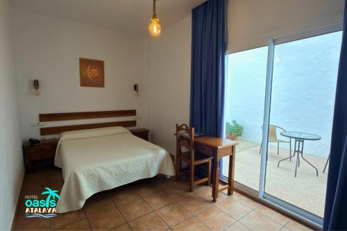 a bedroom with a bed and a view of the ocean at Hotel Oasis Atalaya in Conil de la Frontera