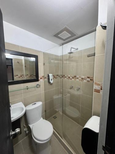a bathroom with a toilet and a glass shower at Balcón Paisa SAS in Medellín
