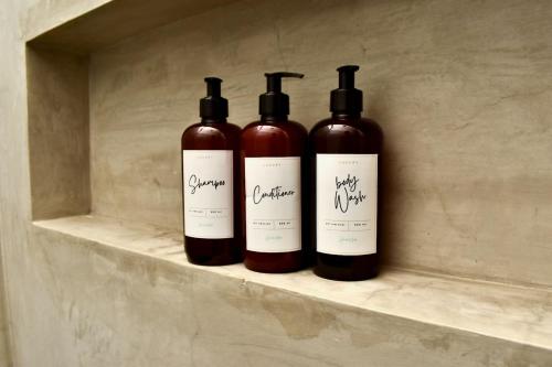 three bottles of wine sitting on a shelf at Ocean view terrace and saltwater pool group getaway in Todos Santos