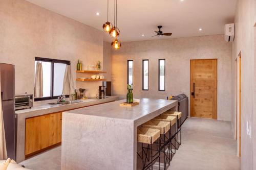 a kitchen with a large island with stools at Sun-drenched escape w sleek saltwater pool in Todos Santos