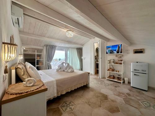 a bedroom with a large bed and a large window at Godano Rooms in Drapia