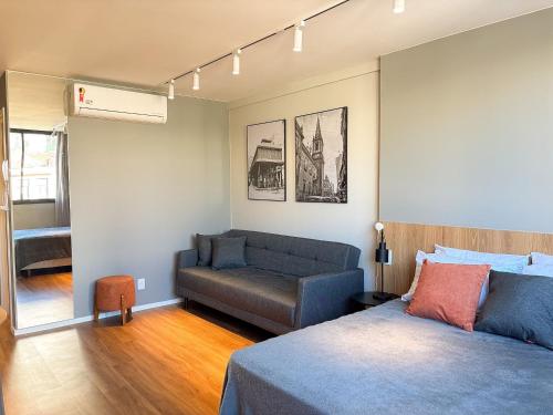 a living room with a bed and a couch at Studio equipado com Piscina espaço histórico. in Rio de Janeiro