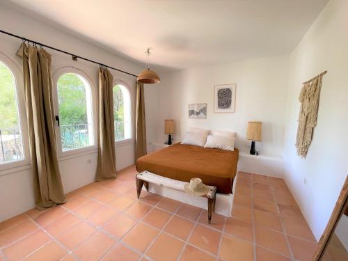 a bedroom with a bed and two windows at Finca LA SELVA, Exclusive Villa in Benimussa in San Antonio
