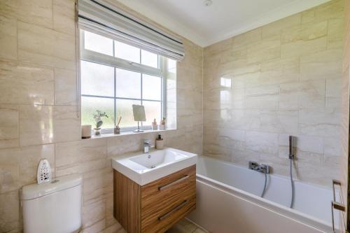 a bathroom with a sink and a tub and a toilet at 3 Bed in Ebberston oc-s35053 in Ebberston