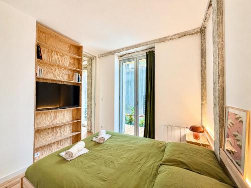a bedroom with a green bed and a window at " L'Atelier Signature " Piscine - Terrasse - Wifi in Toulouse