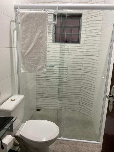 a bathroom with a toilet and a glass shower at mazzonetto ap 03 in Primavera do Leste