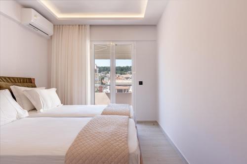 a hotel room with two beds and a balcony at Riviera Zen apartment in Mesochórion