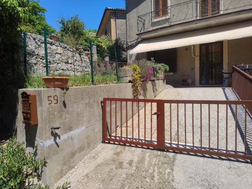 a gate in front of a building with a house at Casa Bonaccorsi in Civitella Del Lago