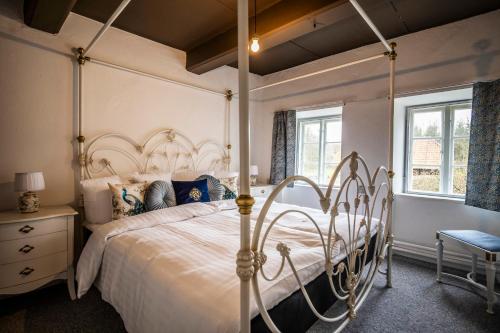 a bedroom with a canopy bed and a chair at Estrup Hovedgaard in Vejen