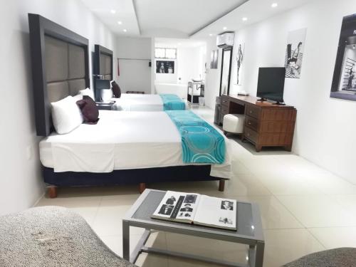 een hotelkamer met twee bedden en een tafel bij Maya Sol Hotel in Cancun