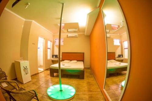 a hospital room with two beds and a mirror at La Passion Motel LTDA EPP in Jaú
