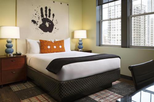 a bedroom with a bed with a hand on the wall at ACME Hotel Chicago, Outset Collection by Hilton in Chicago